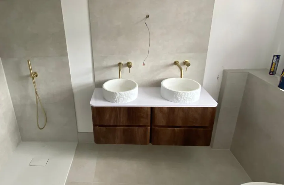 Double vessel basins on a walnut vanity unit with brushed brass taps