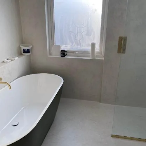 Black freestanding bath with brushed brass shower fittings