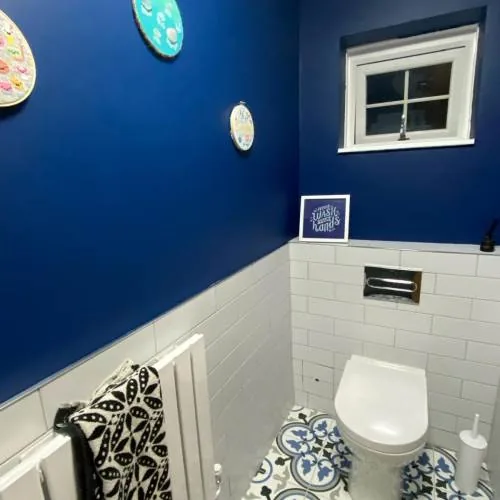 Navy blue cloakroom with metro tiles and patterned floor