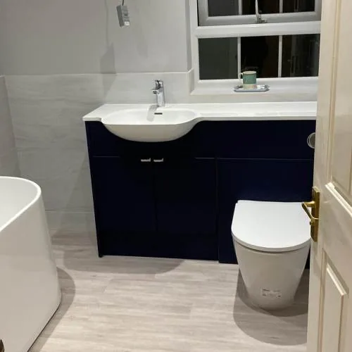 Navy vanity unit with back-to-wall toilet and freestanding bath