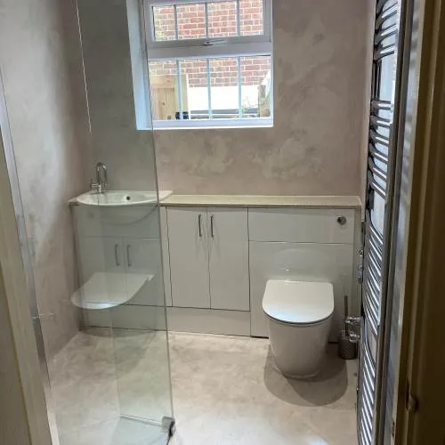 Walk-in shower with frameless glass screen and grey fitted vanity units