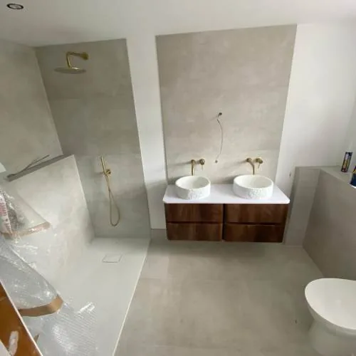 Wet room with double vessel basins and brushed brass taps